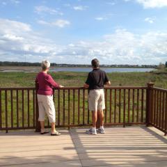 two people standing at a timber balustrade on concrete boardwalk